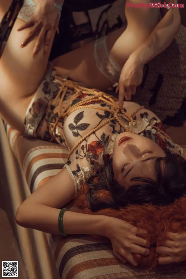 A woman laying on top of a bed next to another woman.
