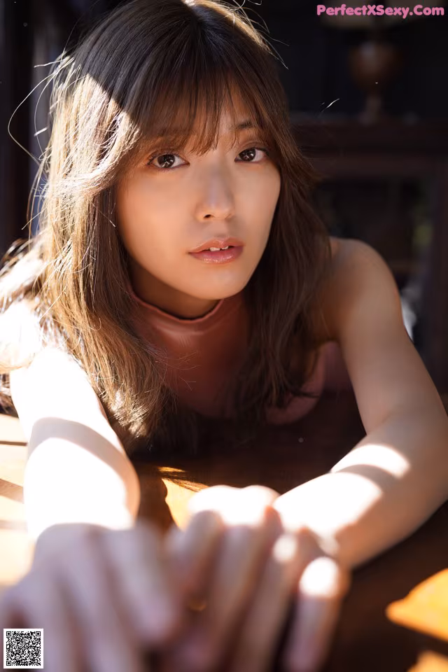 A woman laying on top of a wooden table.