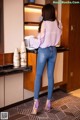 A woman standing in a kitchen next to a counter.