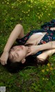 A woman laying on the ground in a field of flowers.