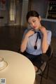 A woman sitting at a table with a cup of coffee.