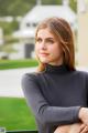 A woman in a black turtle neck top posing for a picture.