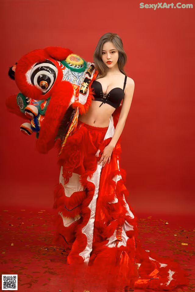 A woman in a red and white dress holding a red lion.