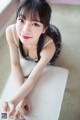 A woman sitting on top of a white table.