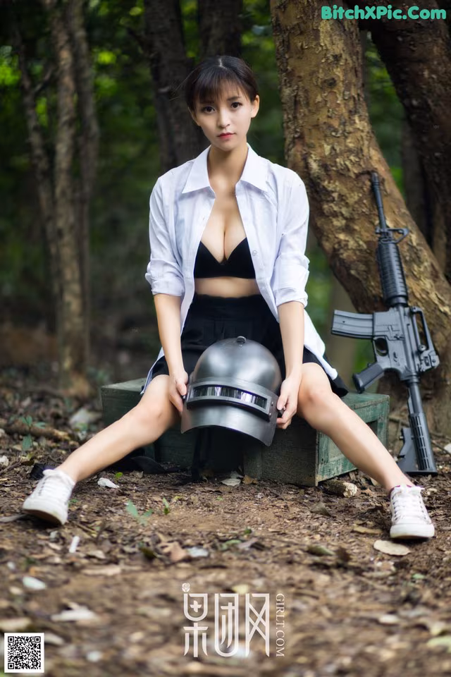 A woman sitting on a bench with a gun and helmet.