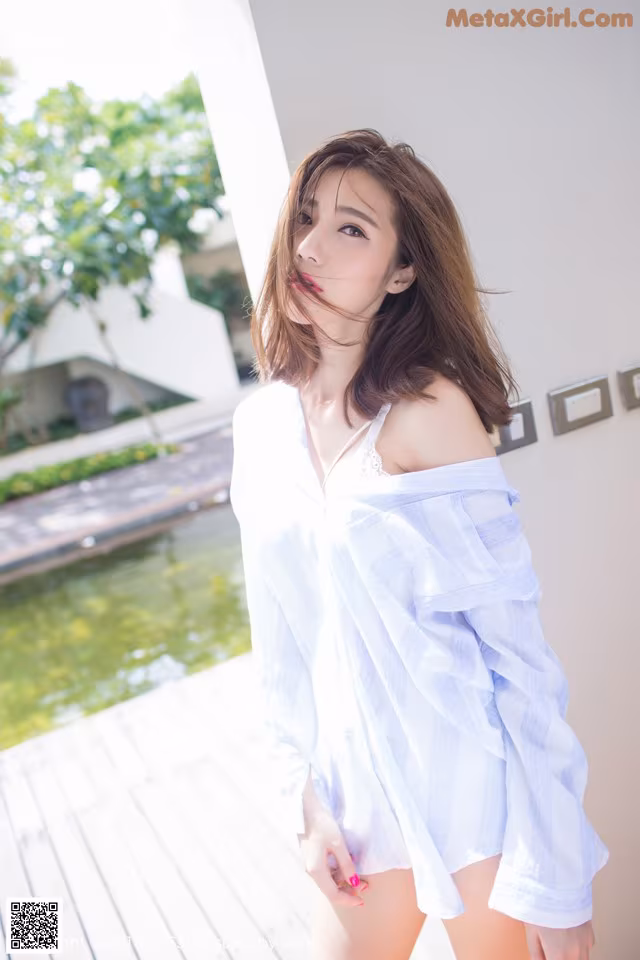 A woman in a white shirt is posing for a picture.
