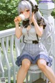 A girl sitting on a porch eating an ice cream cone.