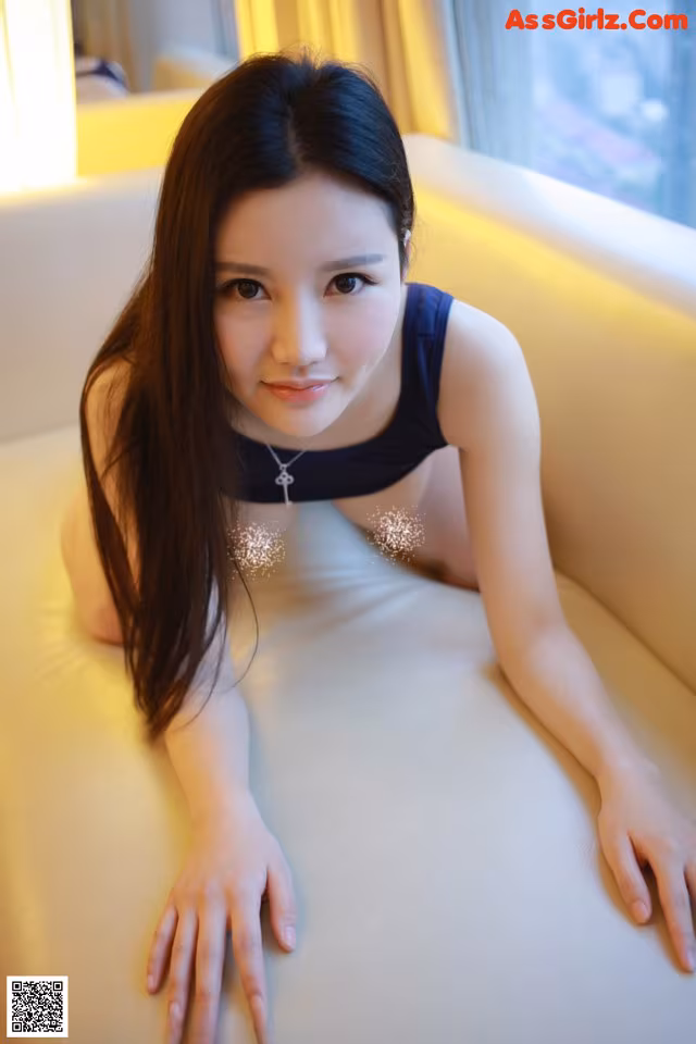 A woman laying on top of a white couch.