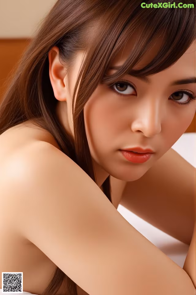 A woman with long brown hair is posing for a picture.