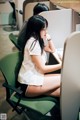 A woman sitting at a desk in front of a computer.